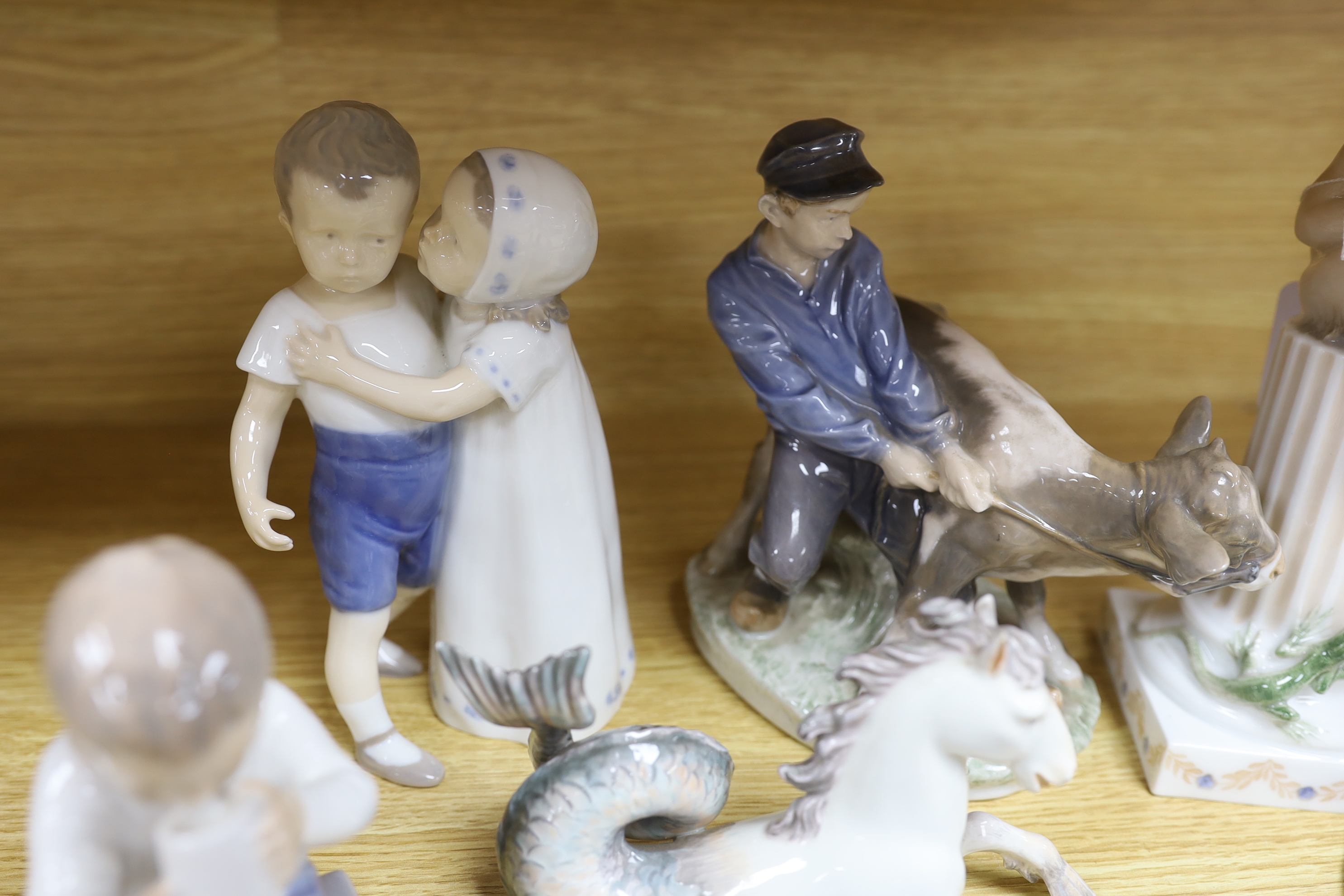 Seven mixed Royal Copenhagen models including children, fish, a fawn, a sailor, a cow and a seahorse (hippocampus), the largest 23cm high